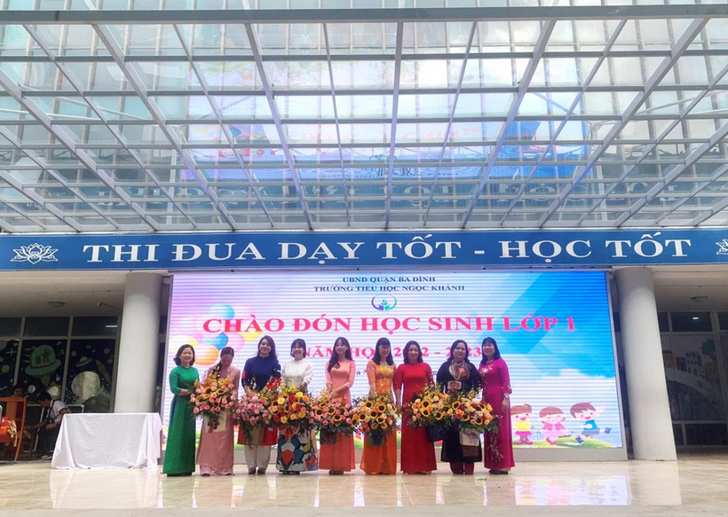 A group of people posing for a photo in front of a glass building  Description automatically generated with medium confidence