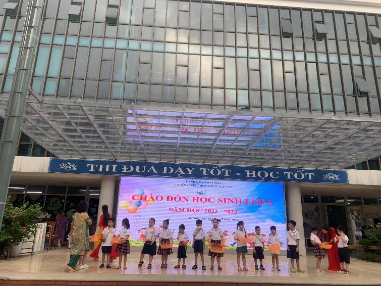 A group of people standing in front of a building  Description automatically generated with medium confidence