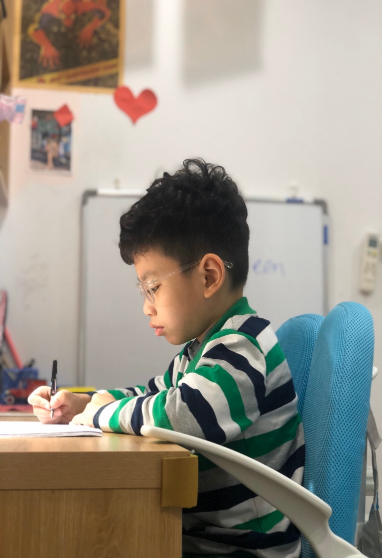 A child sitting at a desk

Description automatically generated with medium confidence