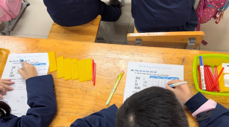 A group of people writing on paper

Description automatically generated with medium confidence