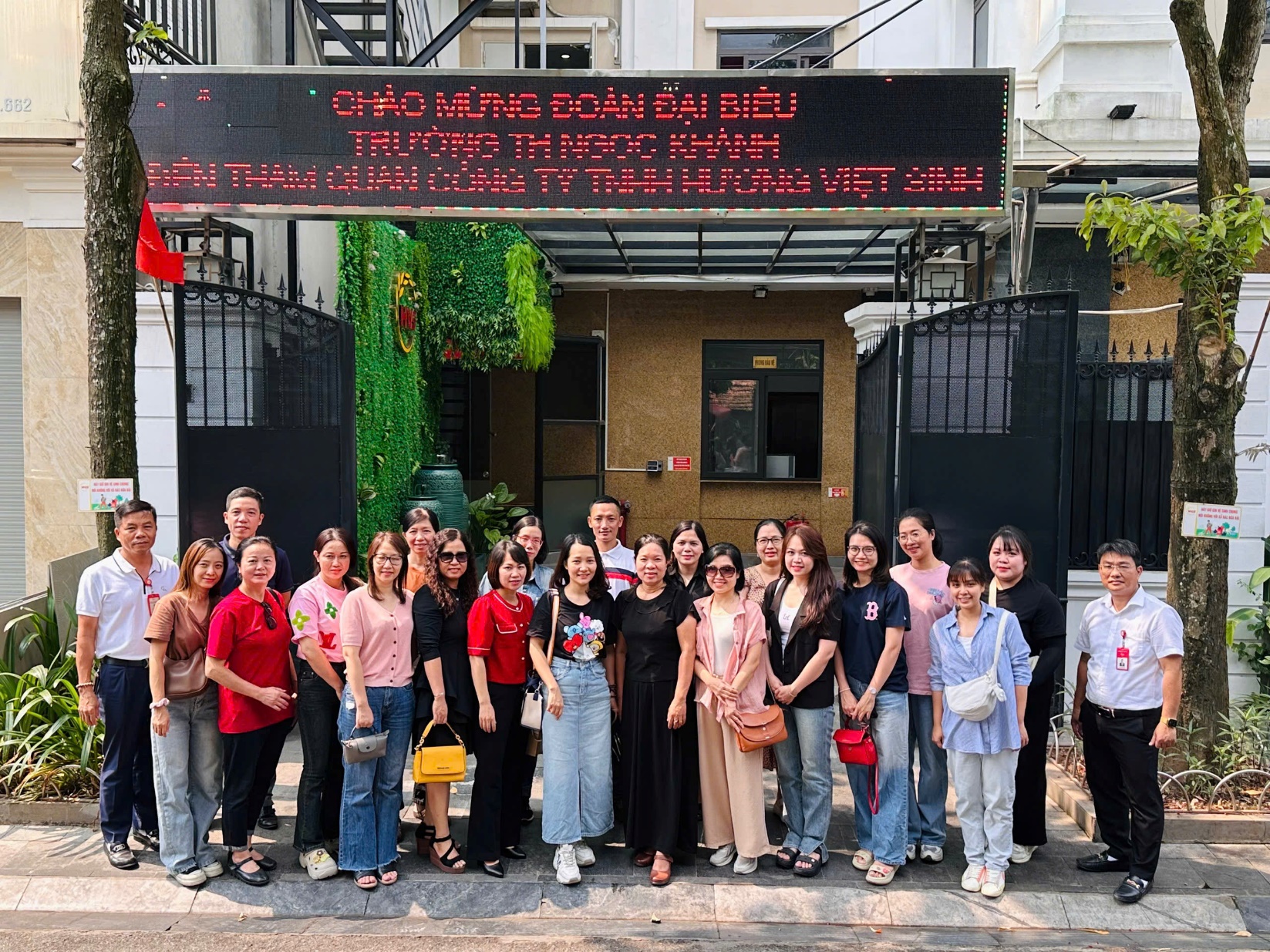 A group of people standing in front of a building

Description automatically generated