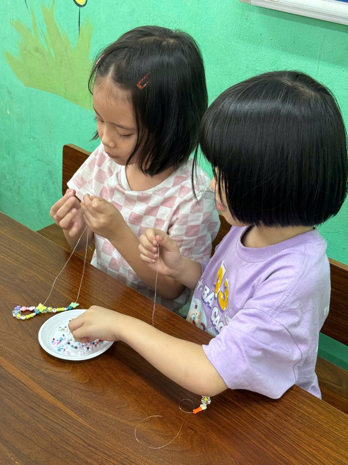 Two girls sitting at a table
Description automatically generated