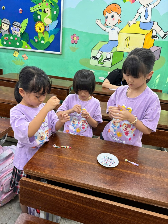 A group of girls sitting at a desk
Description automatically generated