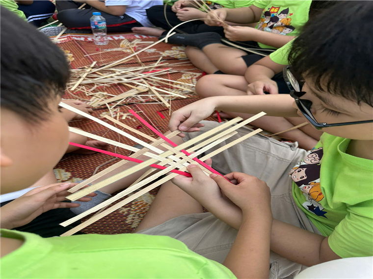 A group of children making a cross-stitch
Description automatically generated with medium confidence