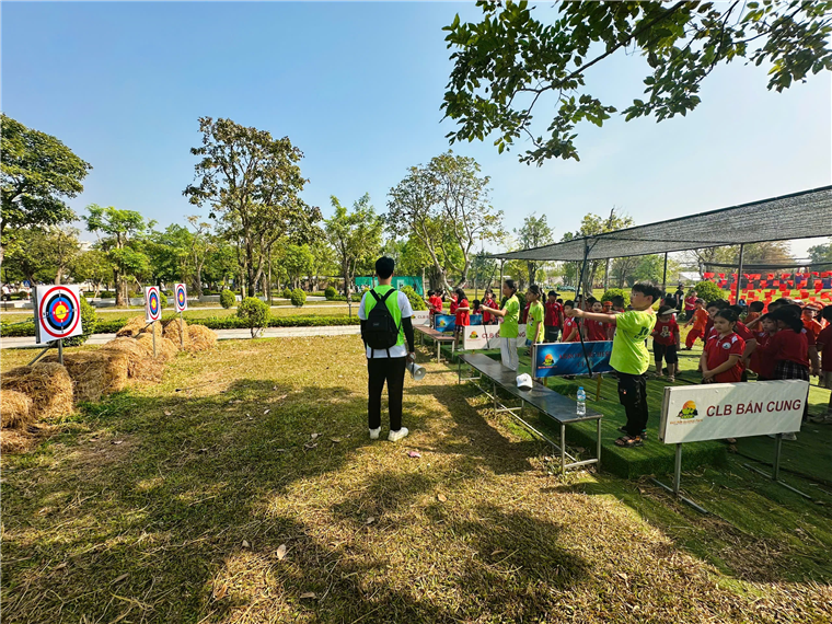 A group of people standing in a park
Description automatically generated