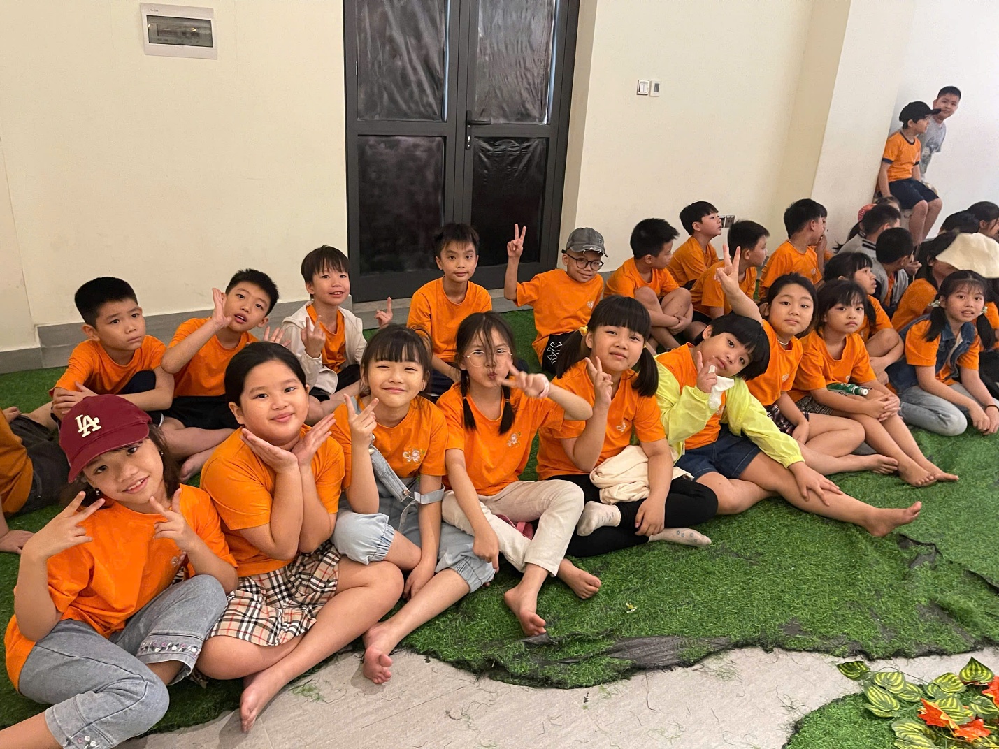 A group of children sitting on the ground

Description automatically generated