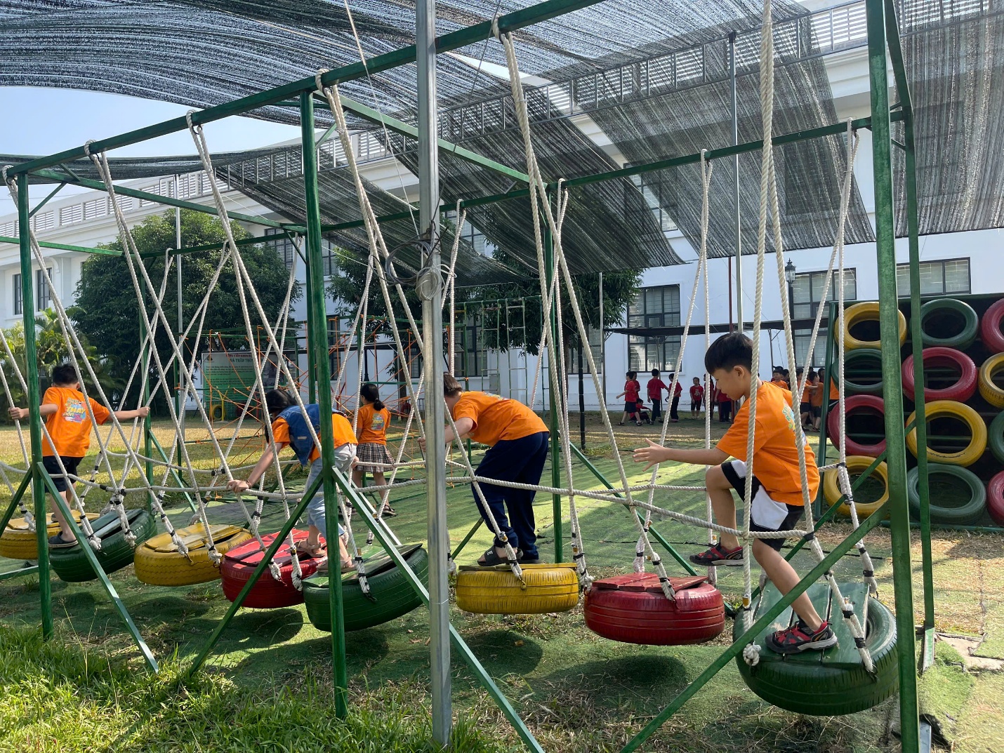 A group of kids playing on a swing

Description automatically generated