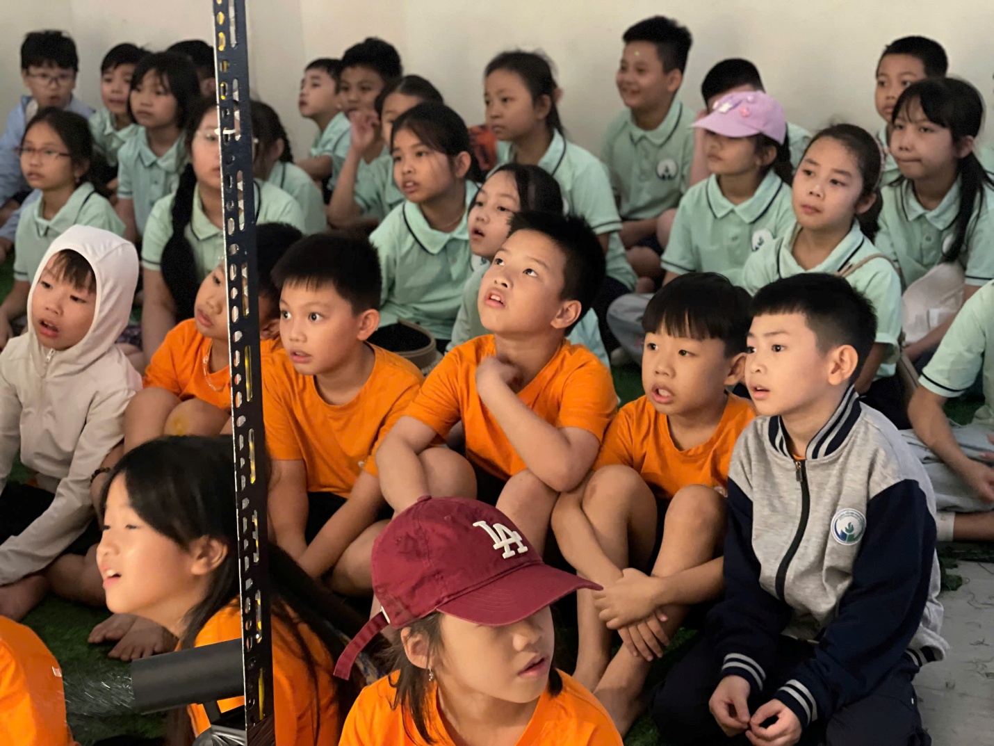 A group of children sitting on the ground

Description automatically generated