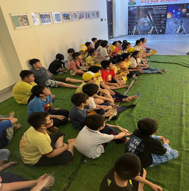 A group of children sitting on the floor

Description automatically generated