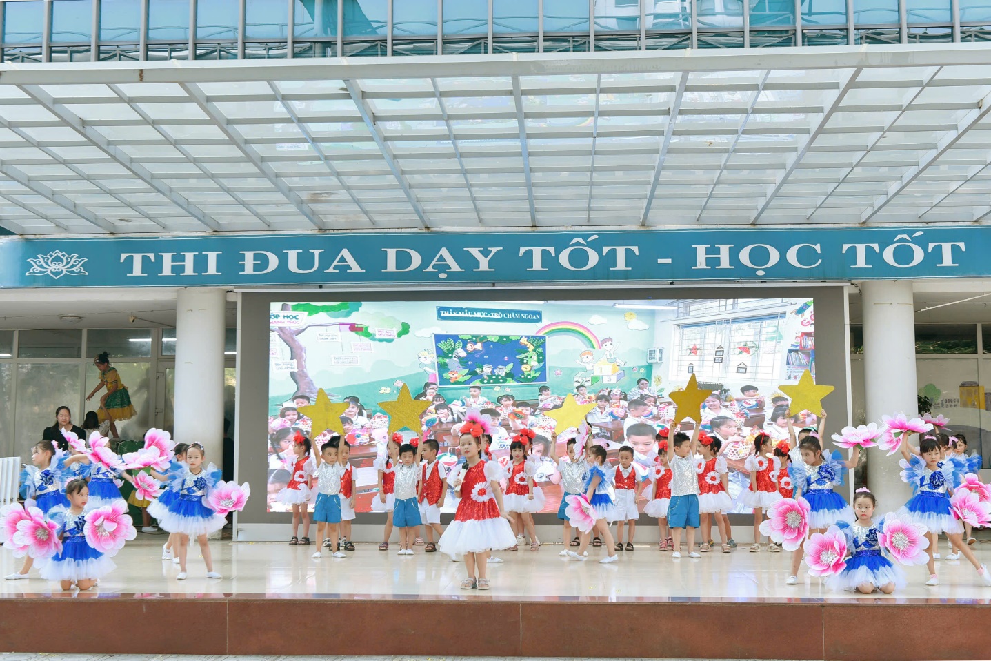 A group of children dancing in front of a building

Description automatically generated