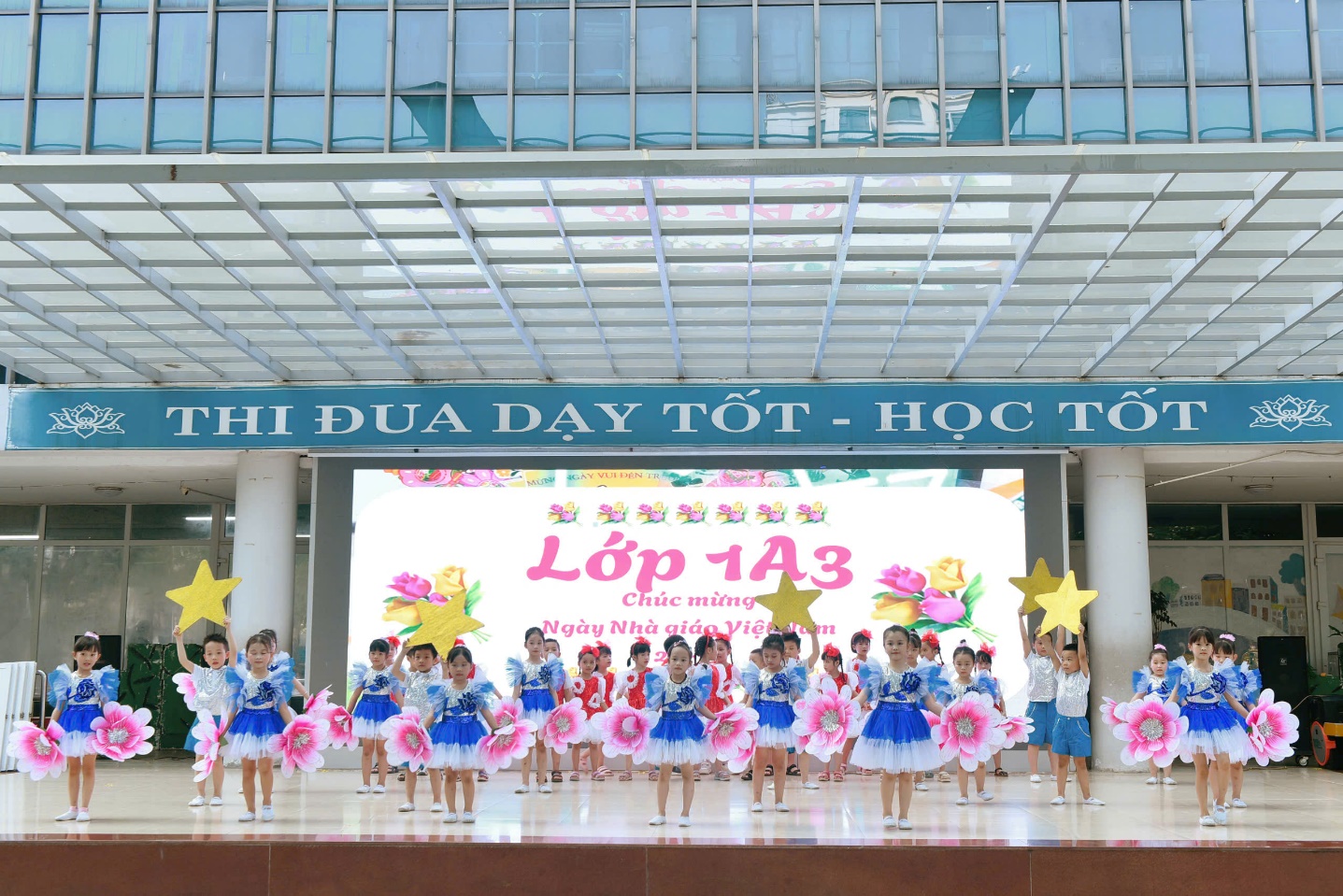 A group of children in blue and white dresses

Description automatically generated