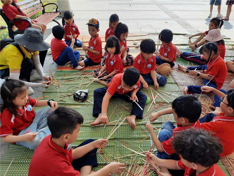 A group of children sitting on a mat

Description automatically generated