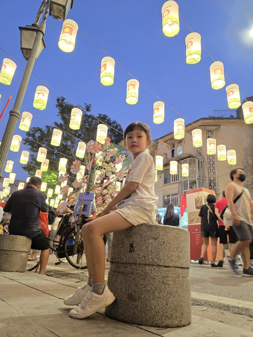 A child sitting on a concrete cylinder
Description automatically generated