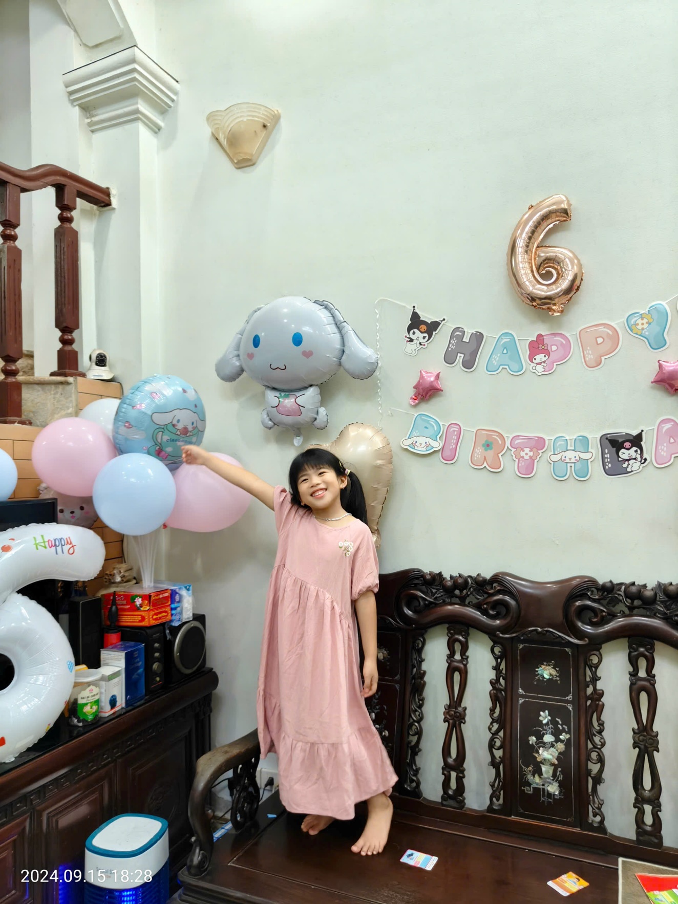 A child standing in a room with balloons
Description automatically generated