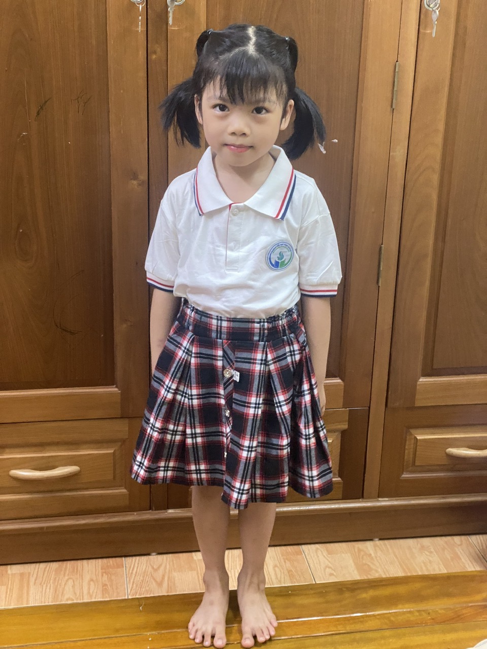 A child standing in front of a wood cabinet
Description automatically generated