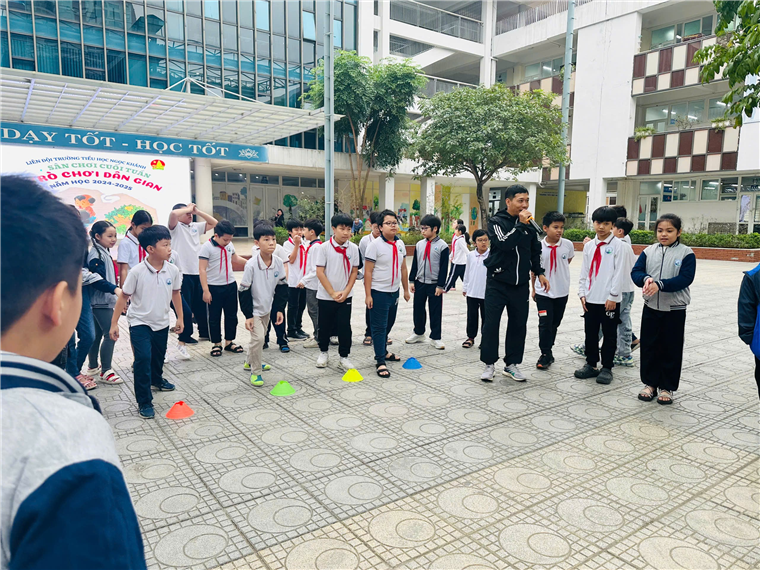 A group of children in white shirts and red ties standing in a circle
Description automatically generated