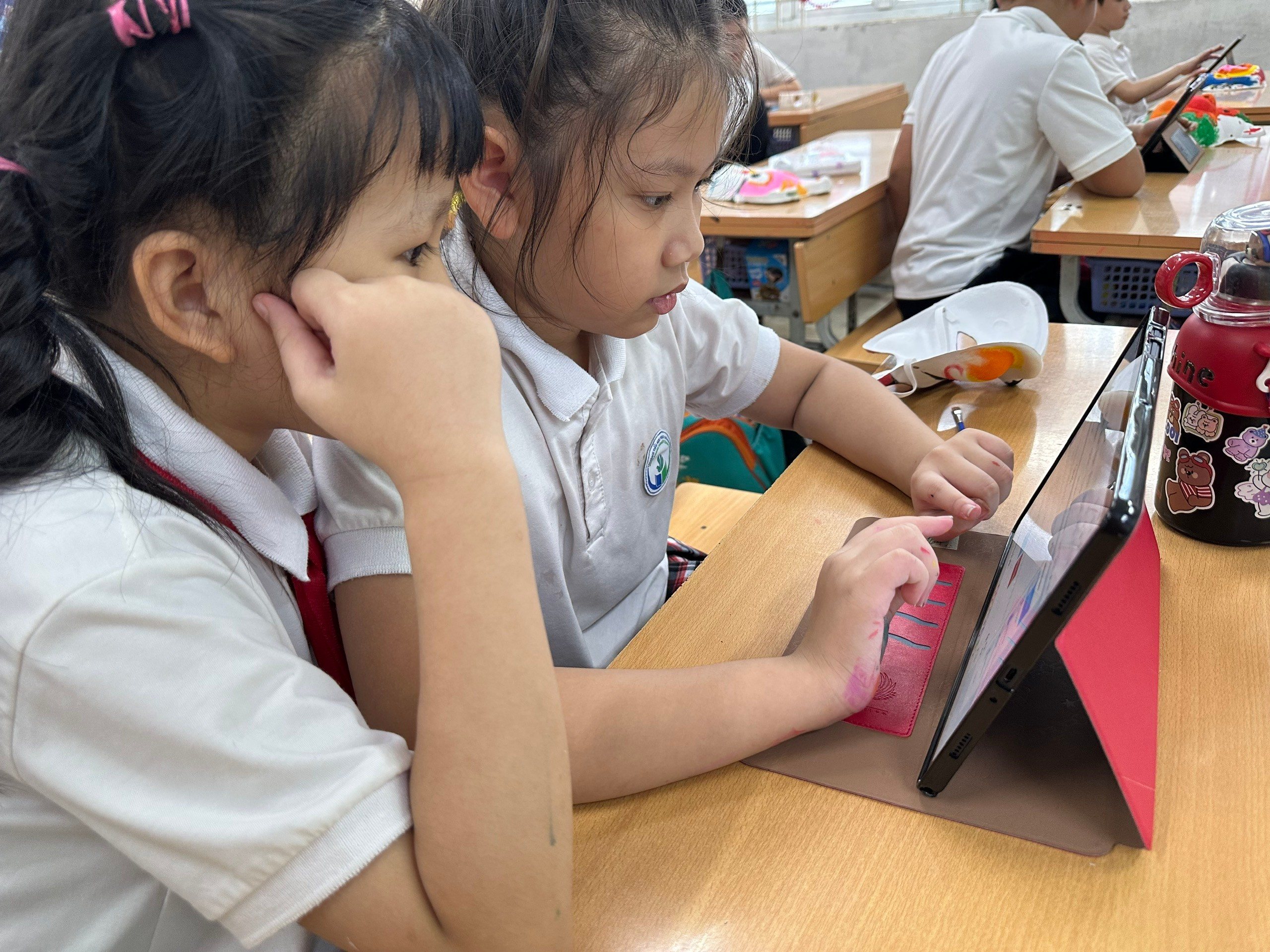 A group of girls sitting at a table using a tablet

AI-generated content may be incorrect.