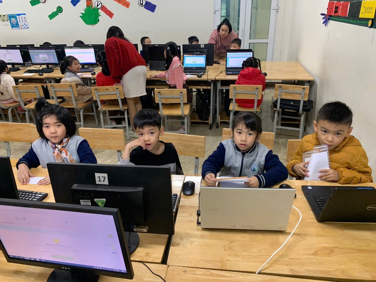 A group of children sitting at a desk with computers

AI-generated content may be incorrect.