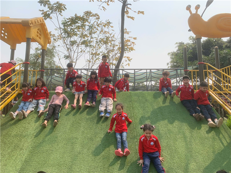 A group of children sitting on a slide

Description automatically generated