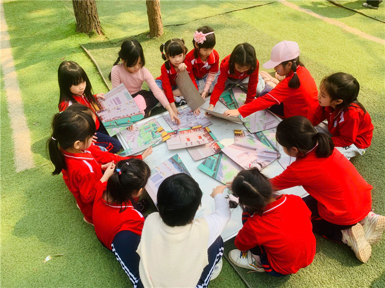 A group of children sitting on the ground in a circle

Description automatically generated