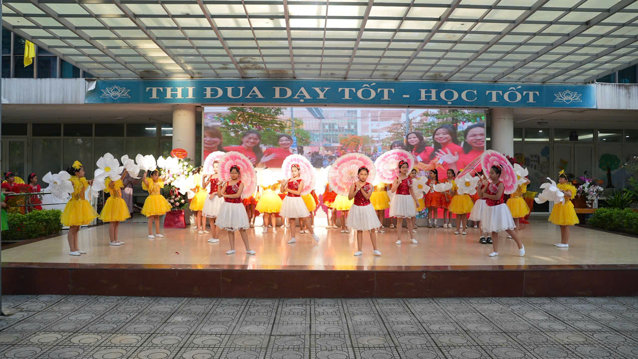 A group of girls in white dresses on a stage
Description automatically generated