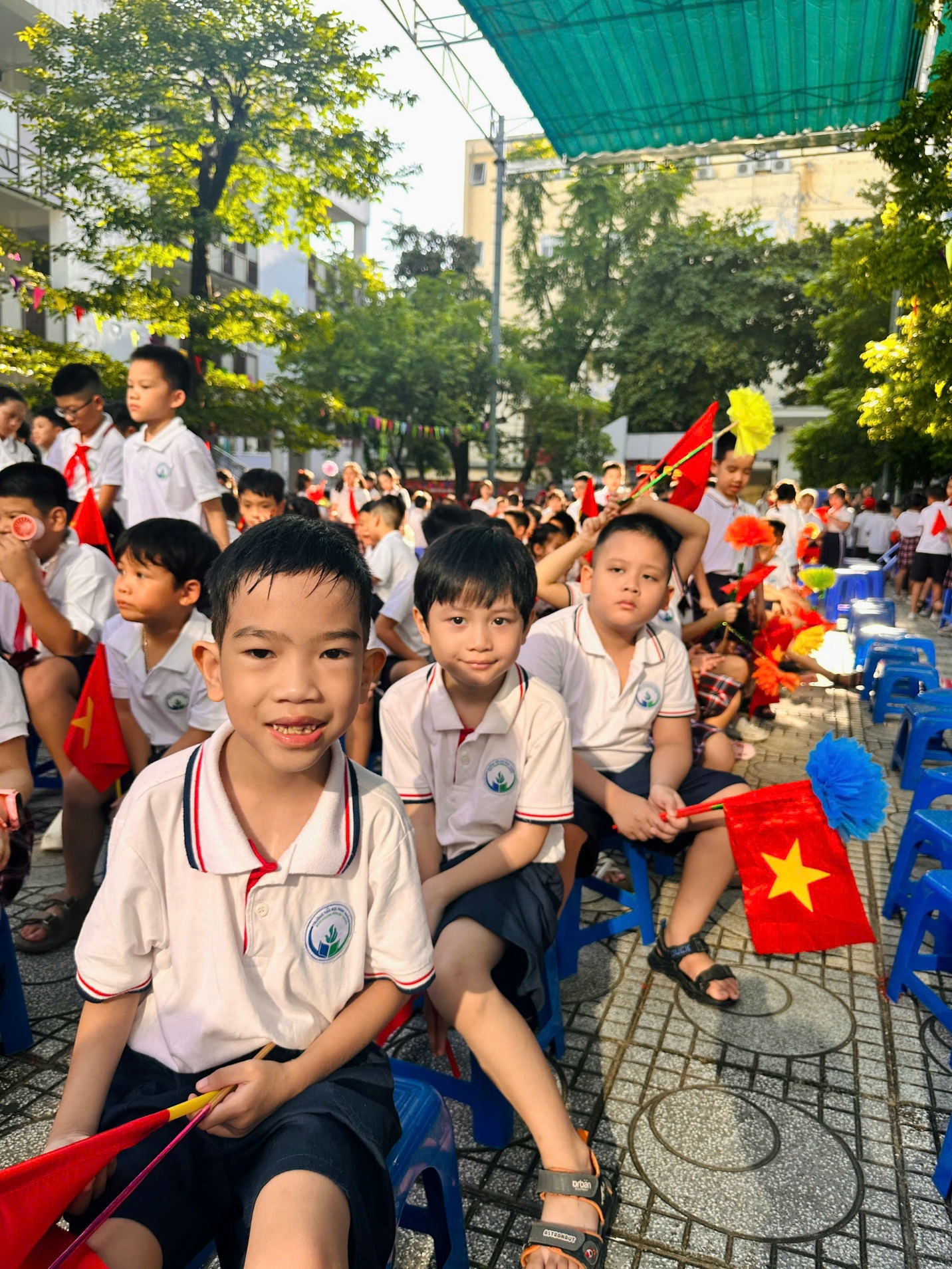 A group of children sitting on blue chairs
Description automatically generated